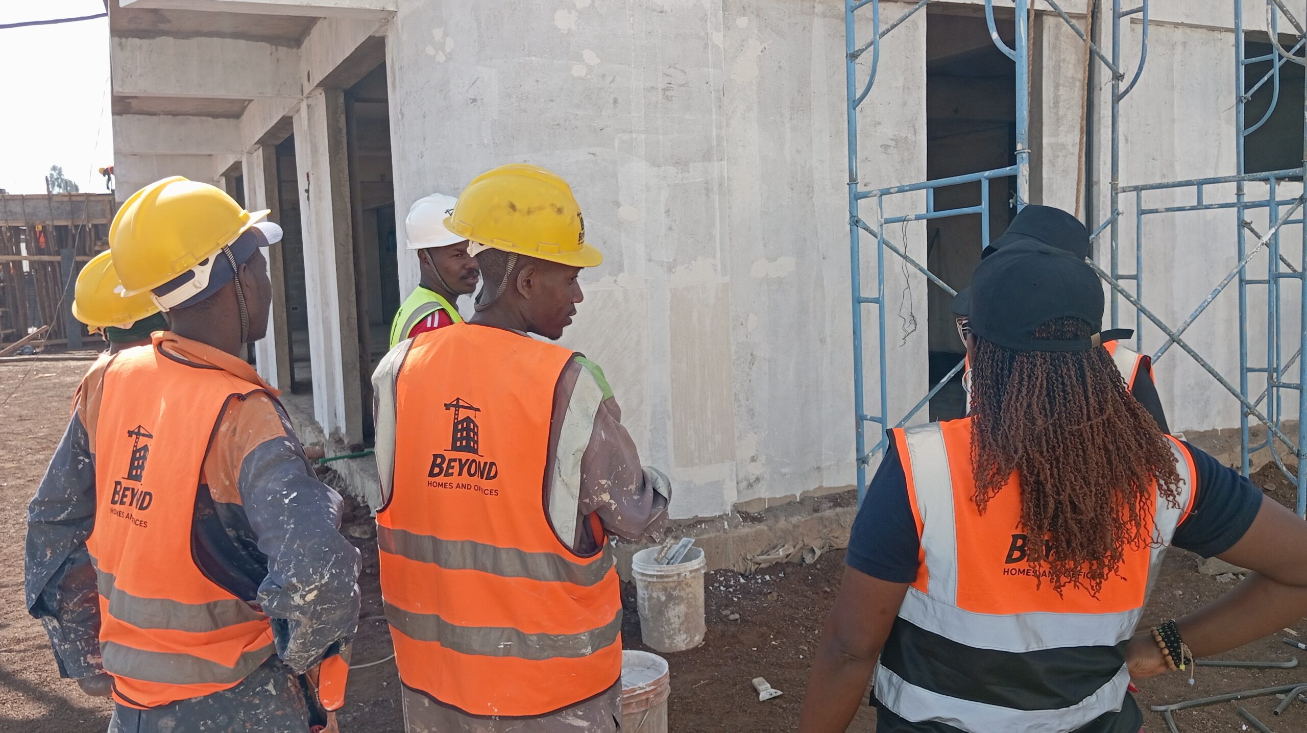 Beyond Homes and Offices team inspecting exterior wall plaster and scaffolding