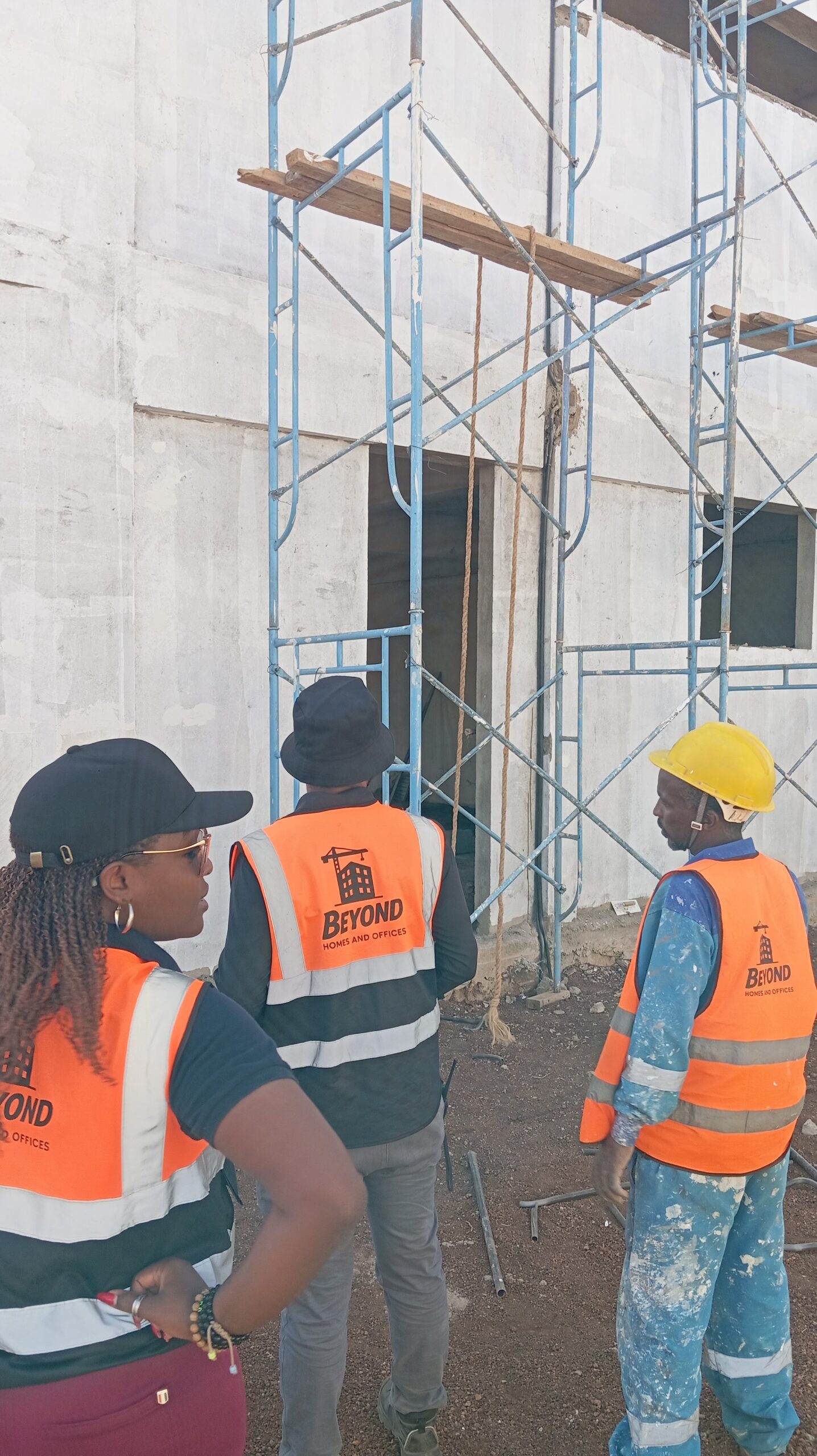Beyond Homes and Offices team reviewing plastered exterior walls and scaffolding
