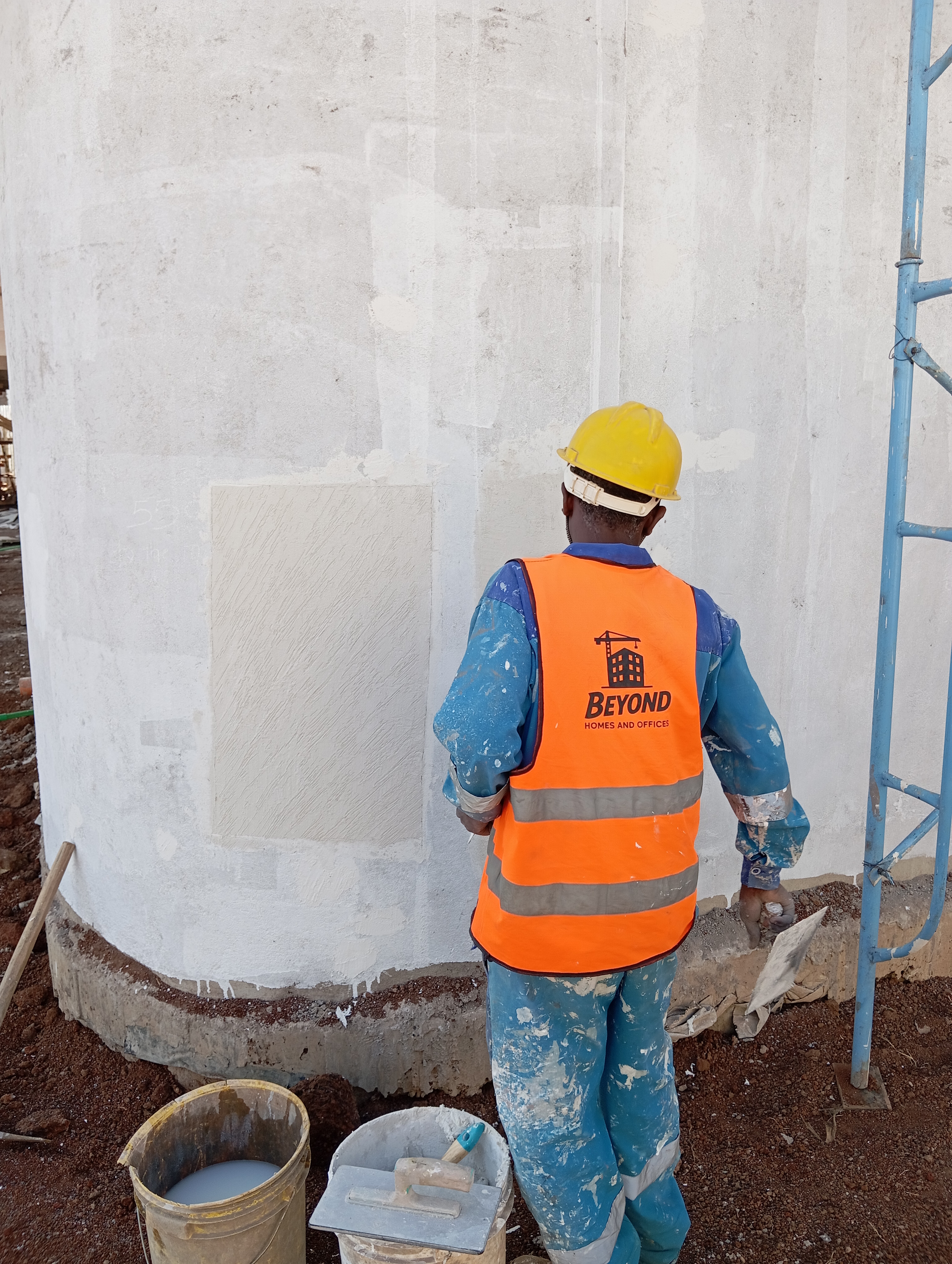 Beyond worker plastering a wall